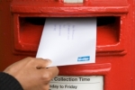 letter being 
posted in a red UK postbox